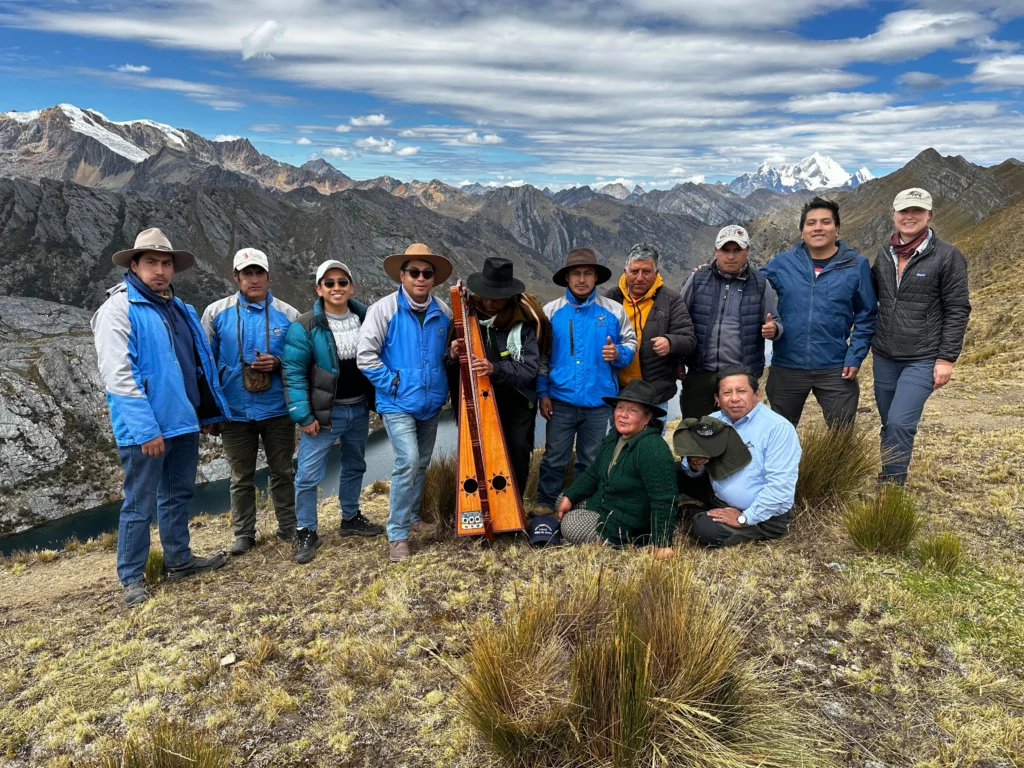 Twelve people posed with mountains in the background.